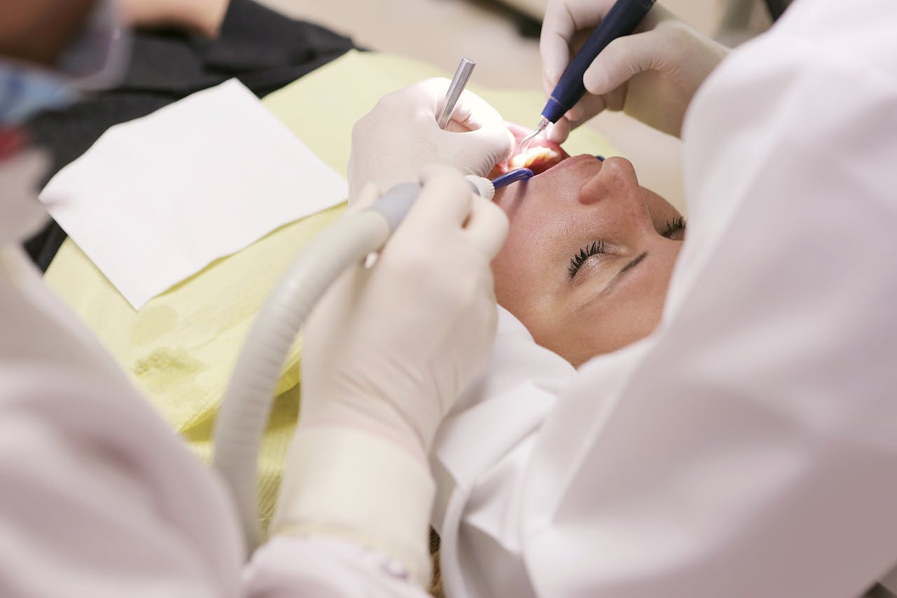 about-01 Close-up of a dentist performing a dental procedure on a patient in a clinic setting.